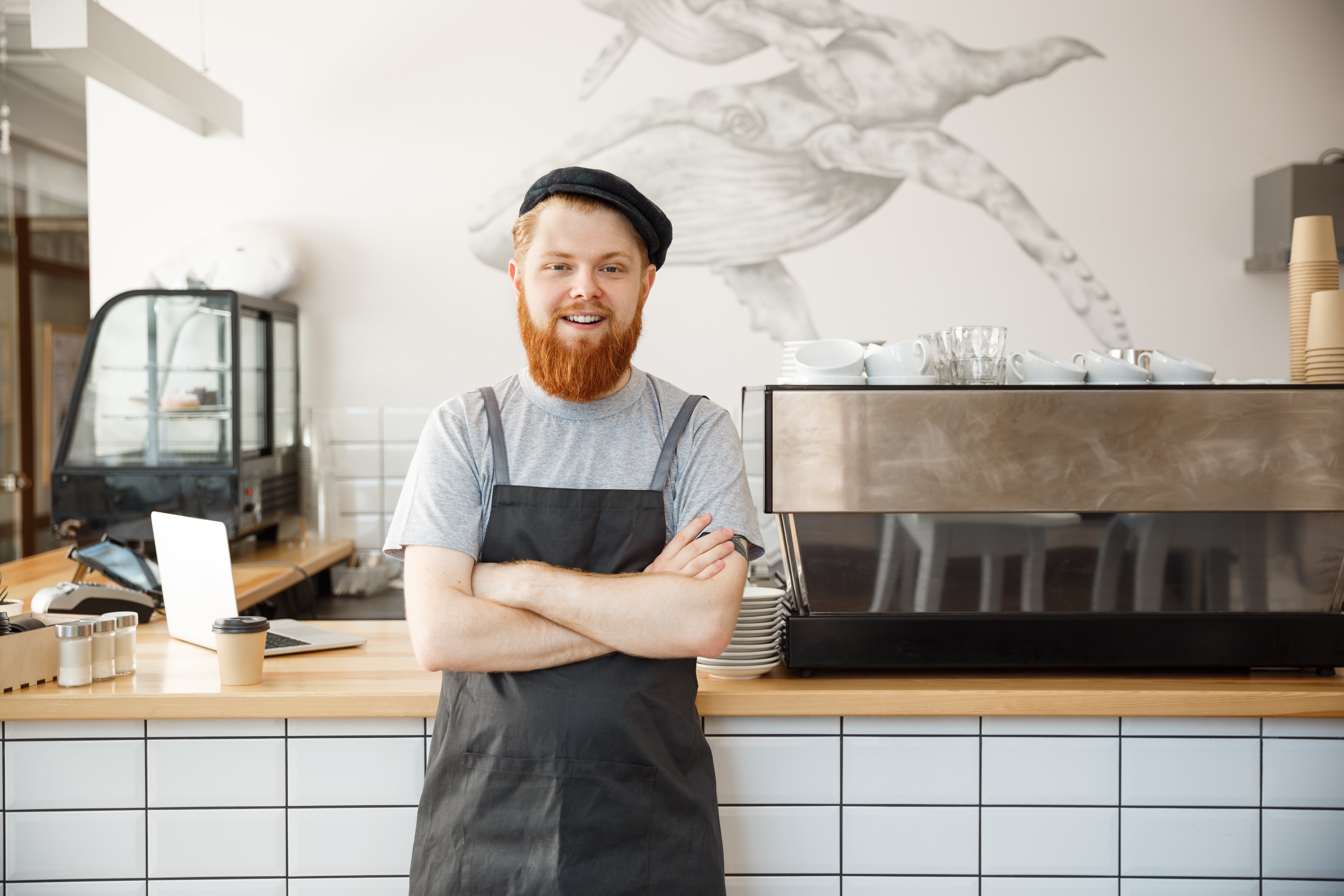 coffee-business-owner-concept-portrait-happy-young-bearded-caucasian-barista-apron-with-confident-looking-smiling-camera-coffee-shop-counter